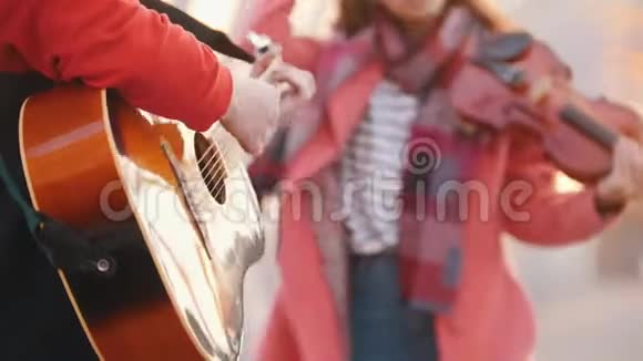 有小提琴的女人和有吉他的男人在街上表演作曲视频的预览图