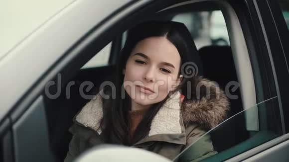 美丽的年轻女子举起她的汽车门的玻璃视频的预览图