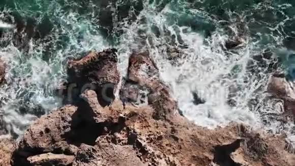 海浪的空中景色近距离观看大型海洋岩石波浪冲击海岸线波浪飞溅海浪创造泡沫A视频的预览图