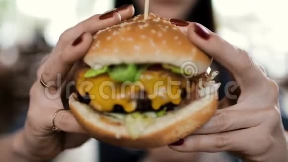 那个女孩拿着一个又大又好吃的芝士汉堡视频的预览图