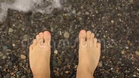 一个人走在鹅卵石滩上一个人脚在水里特写视频的预览图