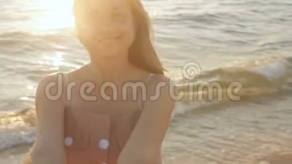 一个幸福的女孩在日出时旋转女人牵着她心爱的男人的手在海滨度蜜月浪漫的假期视频的预览图
