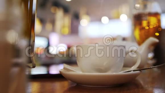 在早餐咖啡馆里把热茶倒进美丽的英式茶杯里慢动作视频的预览图