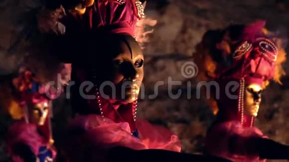女舞者穿着鲜艳的衣服和金色面具的肖像向后退一步并在侧面视频的预览图