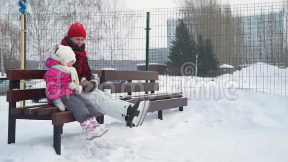冰鞋里的小女孩和女人挥舞着腿视频的预览图