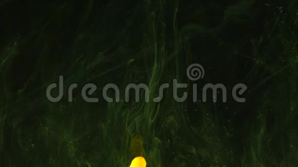 黄色透明的烟雾花出现在黑暗的背景上小点和周围的绿色薄雾视频的预览图
