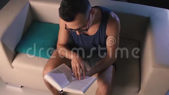 一个视力不好的年轻人读一本迷人的书视频的预览图