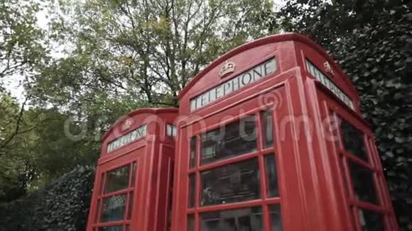 伦敦传统的红色电话亭在街上绿树掩映行动国家标志视频的预览图