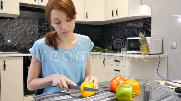 小女孩在厨房里用刀子切鲜黄色的胡椒健康的生活方式和饮食观念视频的预览图