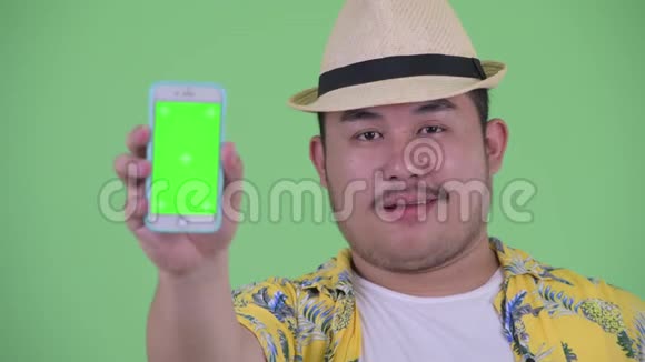 一位年轻体重超重的亚洲游客带着电话视频的预览图