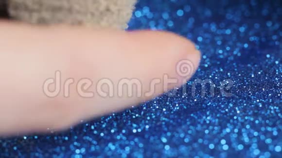 手指在化妆刷上滑动粉末在蓝色背景上飞舞视频的预览图