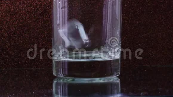 在一个透明的玻璃中冰块落在黑色的背景上视频的预览图