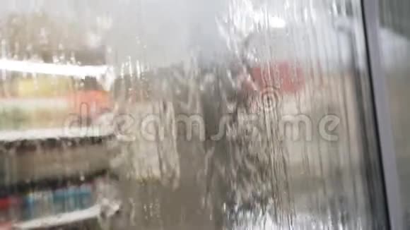 在一场倾盆大雨中一股水柱顺着玻璃往下流闭合视频的预览图