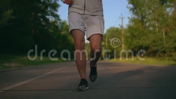 靠近在公路上奔跑的跑步者的脚视频的预览图