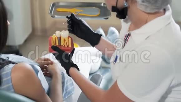 牙医向病人展示牙齿模型在牙科诊所接受咨询的妇女视频的预览图