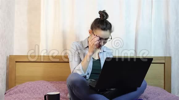 一个年轻漂亮的女孩从笔记本电脑上摘下眼镜视频的预览图