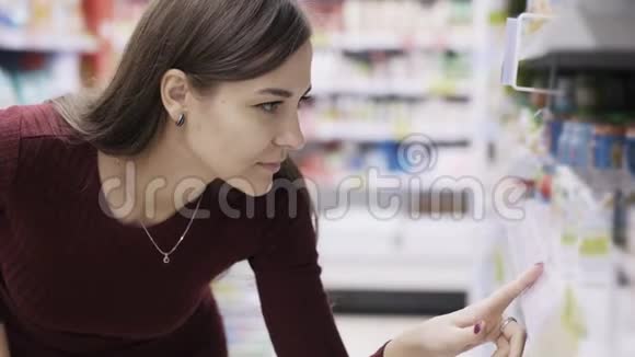 超市里的美女画像正在寻找价格标签和产品视频的预览图