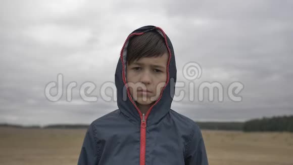 秋天户外雨天户外一个严肃男孩的肖像视频的预览图