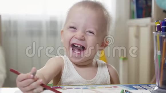 一岁的小男孩拿着铅笔坐在桌子旁视频的预览图