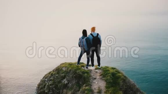 在诺曼底日落的白海岸悬崖上一群快乐的年轻朋友站在一起观看风景视频的预览图