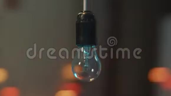 摄像机围绕悬挂在天花板上的一盏闪烁的灯泡动态旋转视频的预览图