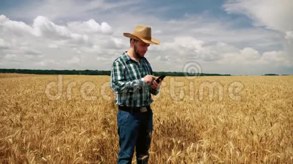 农民在智能手机上刷卡进入谷物种植园视频的预览图