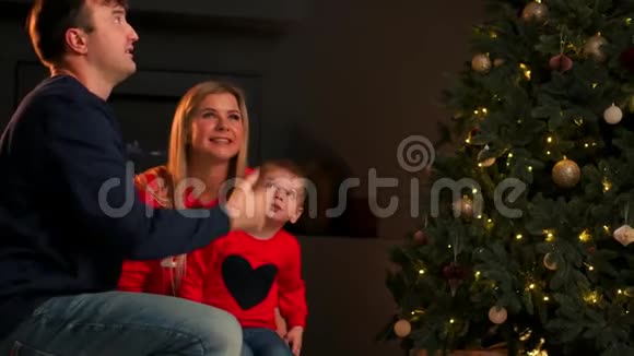 可爱的小男婴在家里玩圣诞夜微笑着拿着圣诞礼物到处跑视频的预览图
