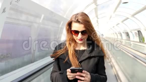 女孩在地铁楼梯上用手机发短信视频的预览图