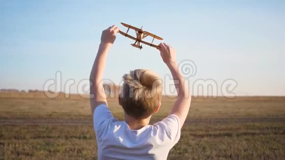 孩子跑过田野举着飞机模拟飞行秋天晴朗的一天户外娱乐视频的预览图