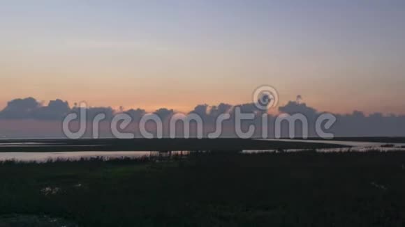日出之前橙色的天空牧场靠近大海视频的预览图