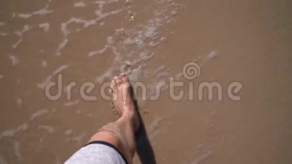 年轻人踏着沙滩上的金色沙滩的视角视频的预览图