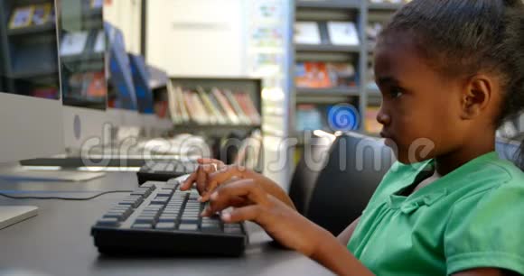 非裔美国女学生在4k学校图书馆使用计算机的侧视图视频的预览图