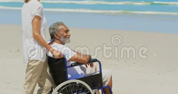 活跃的非裔美国老年妇女和残疾老人在阳光下海滩的侧视4k视频的预览图