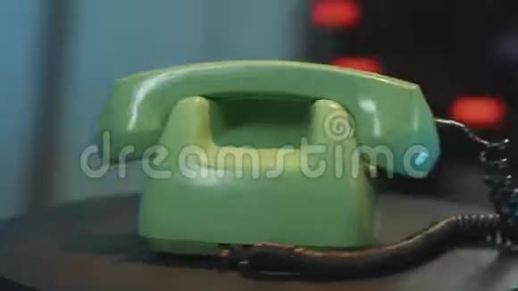 快速旋转相机围绕绿色老式手机与黑色螺旋线桌视频的预览图