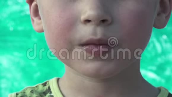 特写一个可爱的小男孩舔了一块美味的糖果视频的预览图