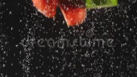 落红绿果蔬溅到波光粼粼的水面上的黑色背景宏观射击关门视频的预览图