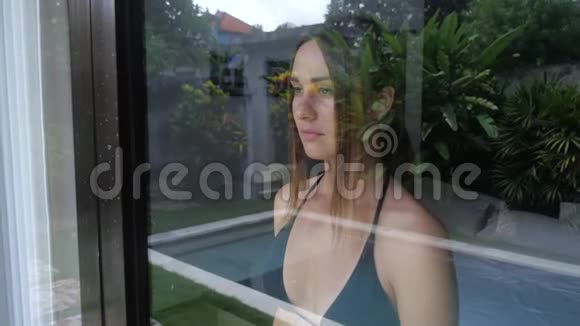 伤心的女人在窗玻璃上道别视频的预览图