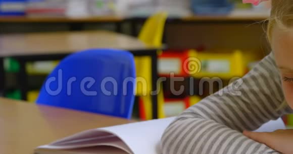 高加索族女学生在4k教室的课桌上睡觉的前景视频的预览图