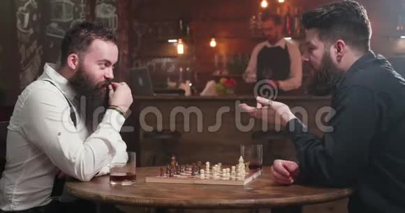 两个时髦的男人为了一杯威士忌和一盘棋而交谈视频的预览图
