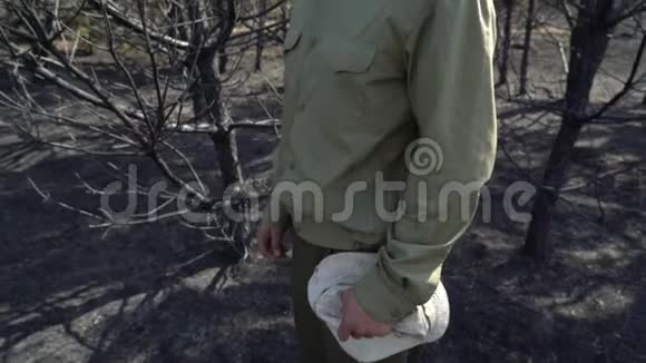 绝望中的人把帽子戴在燃烧的森林里野火生态灾难视频的预览图