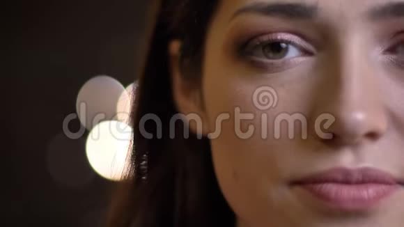 年轻漂亮的白种人女性特写半脸的肖像绿色的眼睛直视着镜头视频的预览图