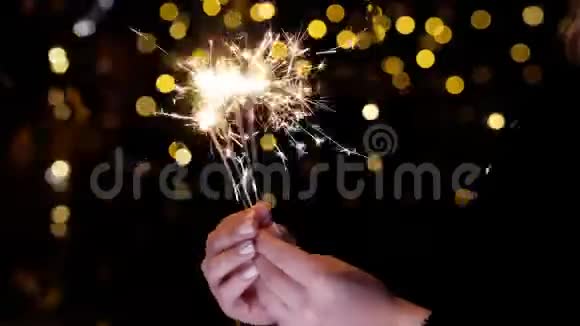 燃烧的火花在手中闪烁着明亮的光芒金色的火花飞散开来视频的预览图