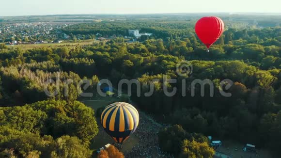 日落时热气球在公园的树间起飞空中镜头视频的预览图