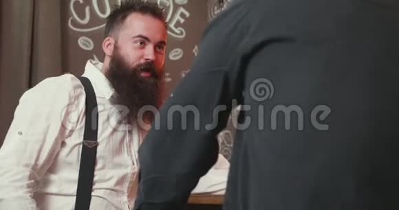 在酒吧柜台喝一杯威士忌的时髦大胡子男人视频的预览图