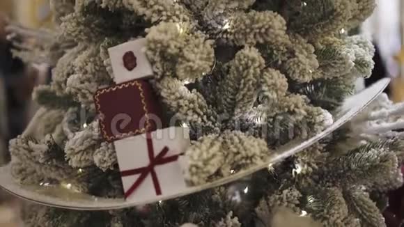 用小礼品盒将雪地里的人造圣诞树合上视频的预览图