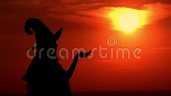 女巫在太阳升起的背景上吹着魔法粉末视频的预览图