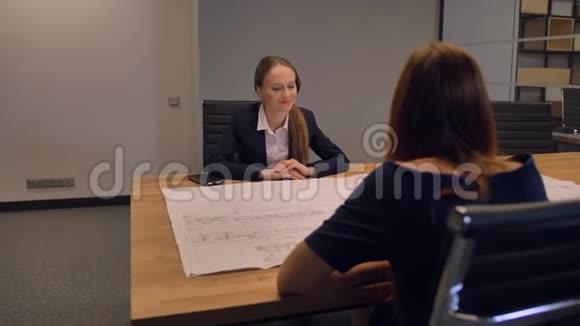 有魅力的年轻女士专家工程师看着图纸在会议室里填写文件视频的预览图