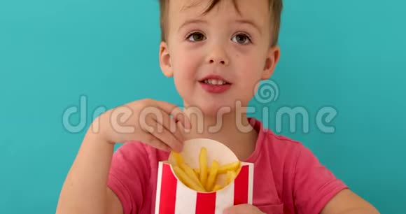 小男孩在室内吃鱼和薯条微笑视频的预览图