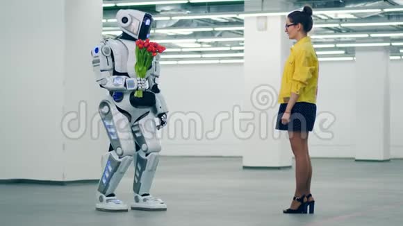 一个高大的机器人正在空厅里给一个女人送花视频的预览图