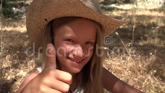 快乐的孩子出现大拇指标志女孩肖像躺草笑孩子脸4K视频的预览图